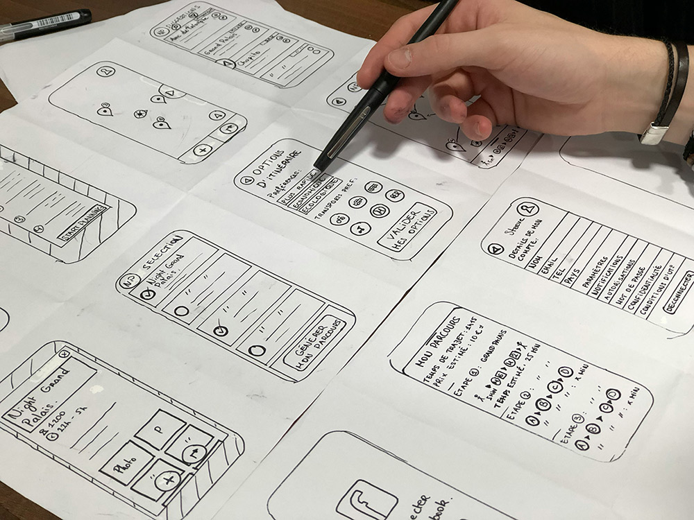 Designer sketching packaging layouts in a notebook