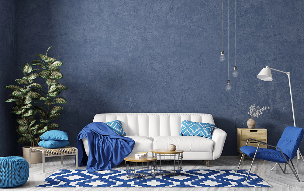 Modern interior of living room with white sofa, coffee tables, blue rug