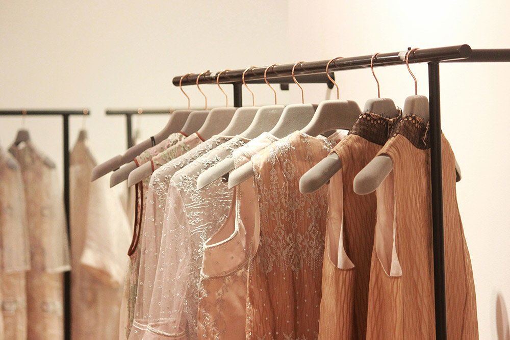 Embellished occasion dresses hanging on a rail in a boutique